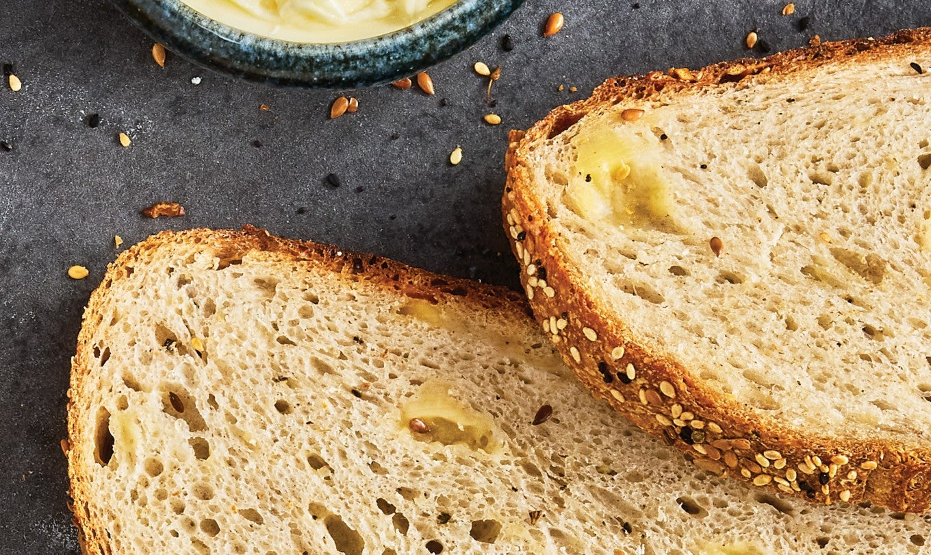 Two slices of parmesan pepper bread with lovely pockets of parmesan and black pepper.