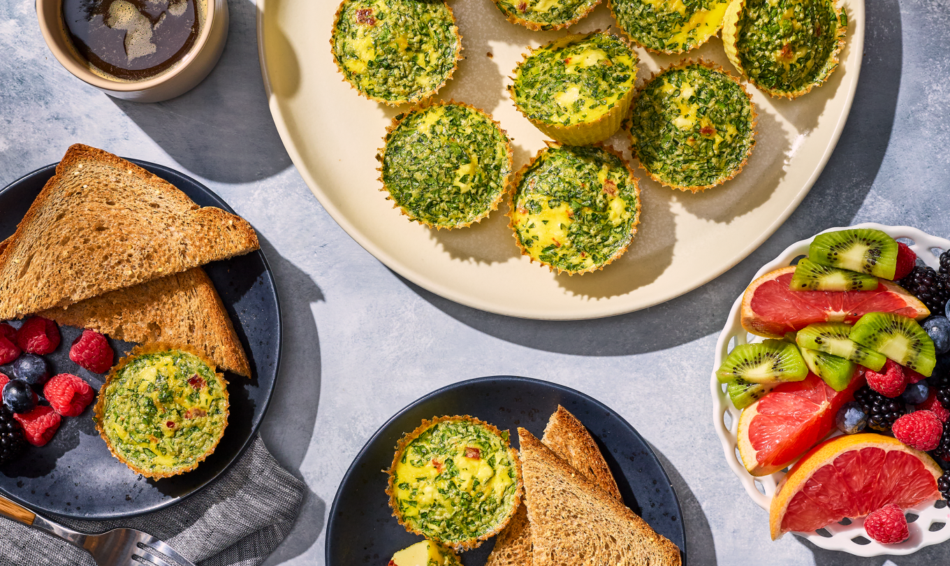 Egg Bites and breakfast spread with fresh fruit and toast on a counter.