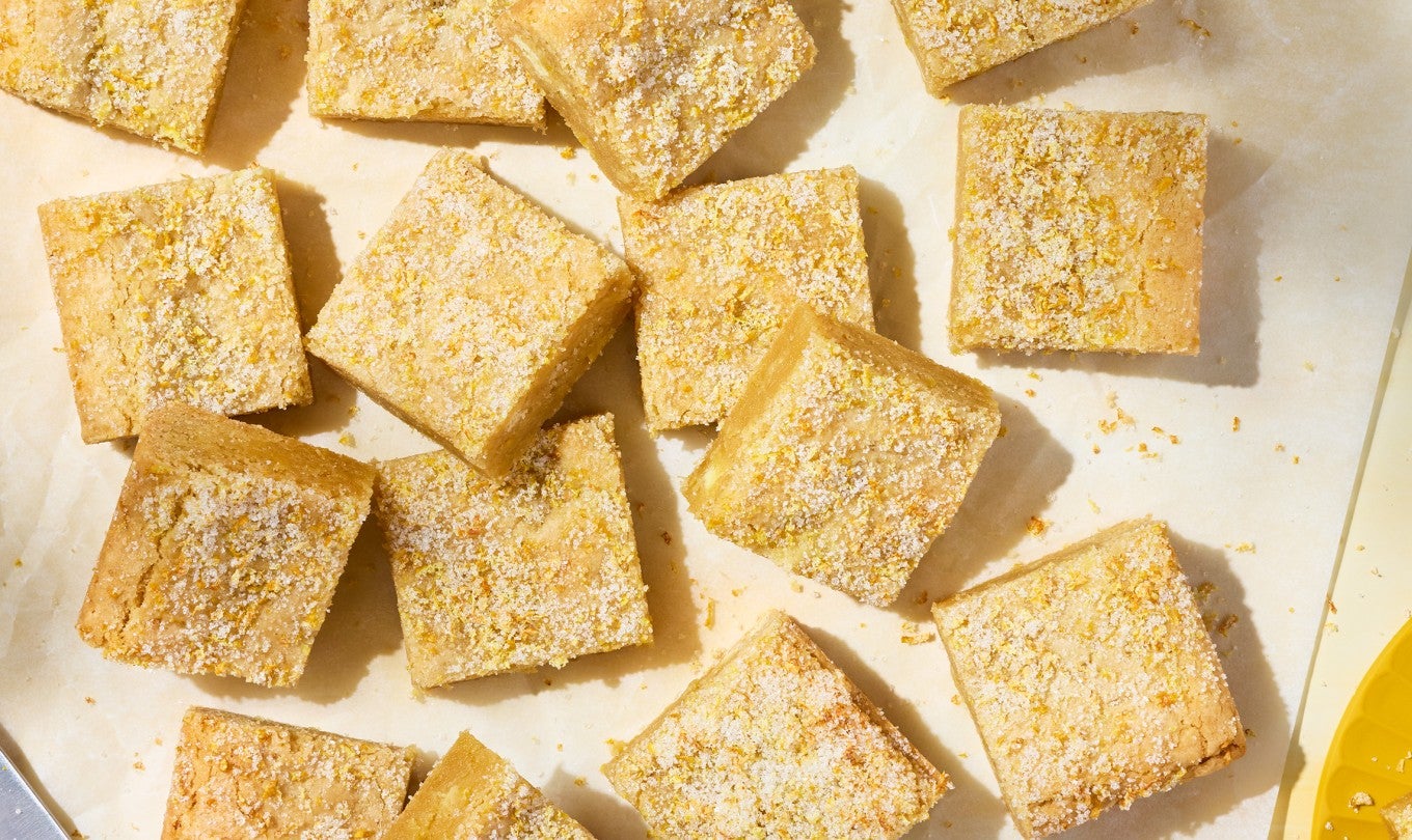 Alex Roberts Lemon Citrus Blondies on parchment paper atop a counter.