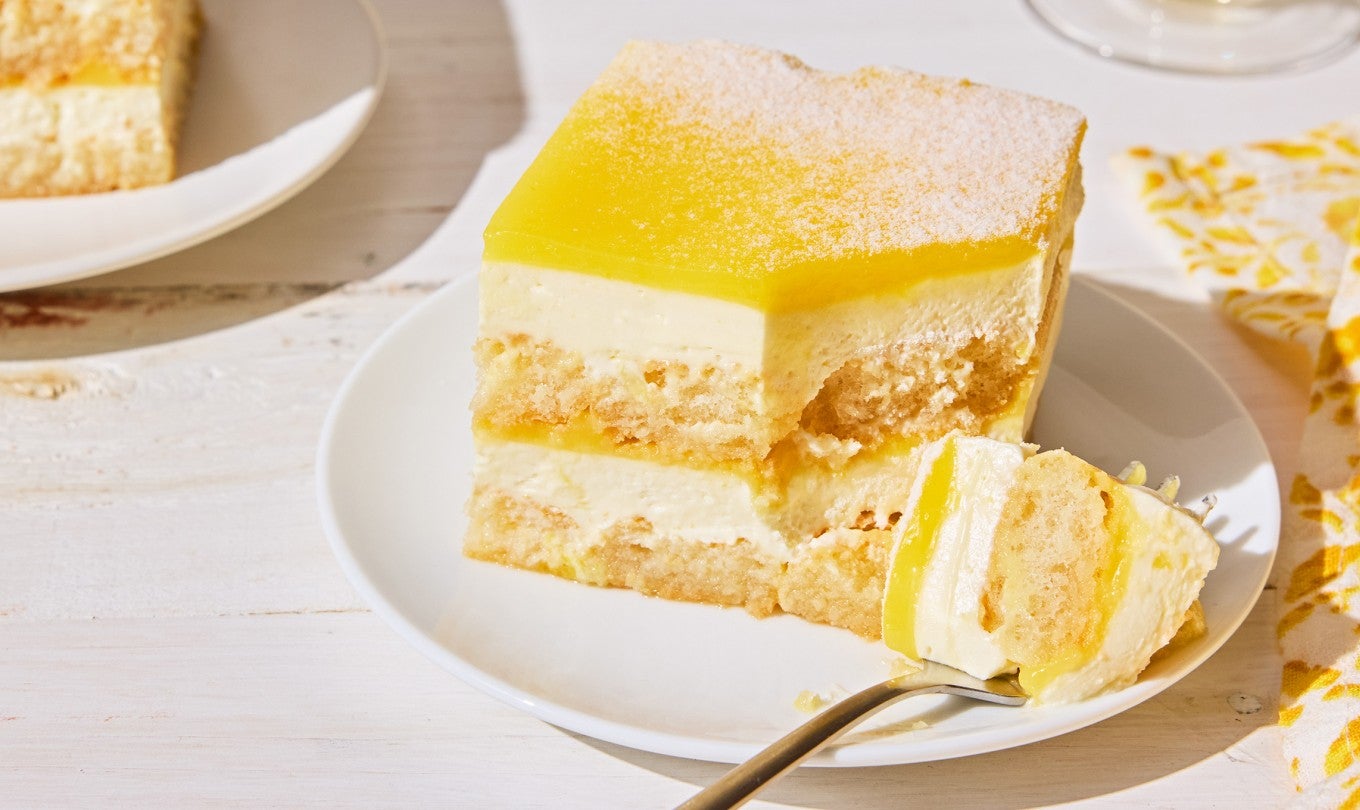 Slices of Lemon Tiramisu on plates with a bite shown on a fork.