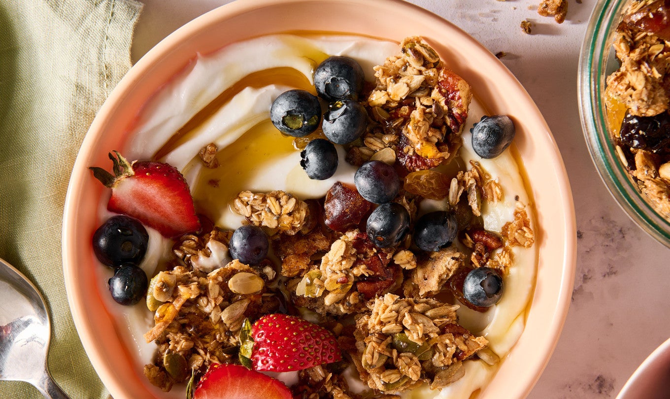 Sourdough Granola atop some yogurt in a bowl along with fresh fruit