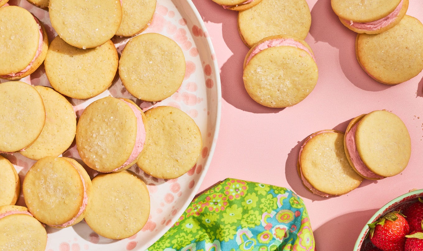 Strawberry Shortcake Cookies seen from above on a pink counter and piled on a plate