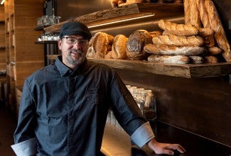 Chef John Kraus in front of shelves of baked goods