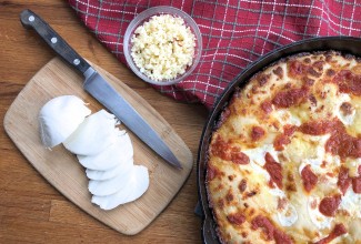 Mozzarella and jack cheeses beside baked pizza.