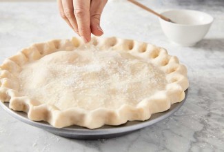 Sprinkling sugar on unbaked pie crust