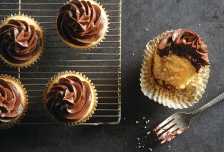 Vanilla cupcakes topped with chocolate frosting and filled with pastry cream