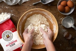 Hands in bowl of flour