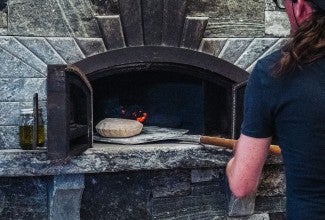 Sliding pita into a wood-fired oven