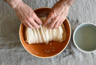 Hands folding bread dough