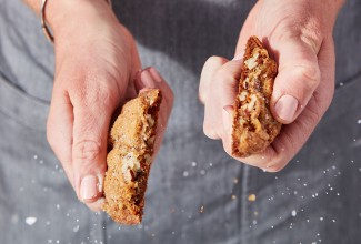 A Salty-Sweet Butter Pecan Cookie being snapped in half.