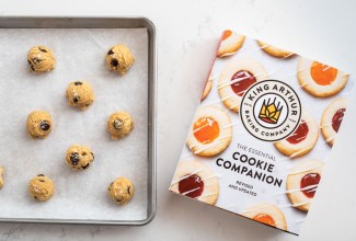 The Essential Cookie Companion book and unbaked drop cookies on a baking sheet.