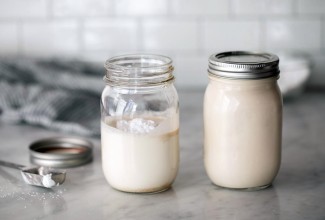 Two mason jars, one filled with cream ready to be shaken and the other filled with whipped cream