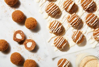 Eggnog truffles drizzles with glaze, some broken in half to reveal a creamy center