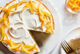 A layer cake garnished with candied oranges and a cream filling