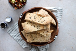 A bowl of Afghan naan topped with black and white sesame seeds