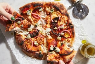 Hands pulling slices of baked No-Knead Artisan Pizza