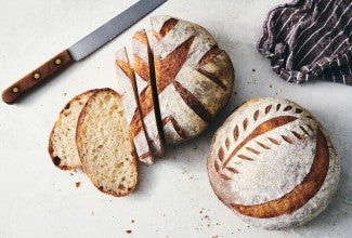 One loaf of sliced sourdough and one whole loaf of sourdough