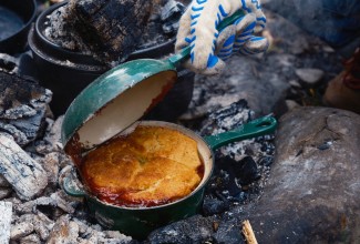 Fruit cobbler being baked over a campfire