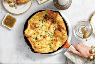 Savory Herbed Parmesan Dutch Baby being served in a cast iron skillet