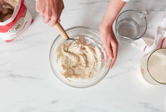 Hands mixing bread dough