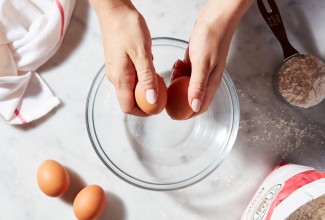 Hands cracking two eggs against each other