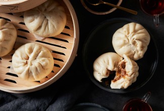 Steamed buns next to steamer full of buns