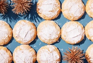 Baked cookies laying in rows on a blue background.