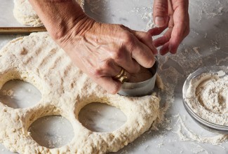 Hands cutting out biscuit dough