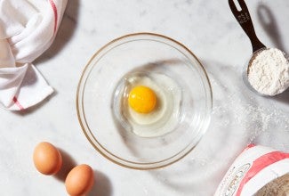 Egg cracked into a clear bowl