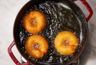 Doughnuts being fried in vegetable oil