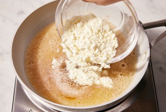 Baker pouring milk powder into browning butter