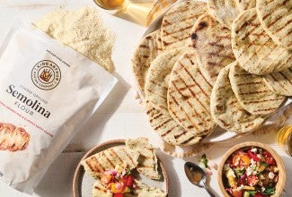 Bag of semolina flour next to grilled Asiago rounds