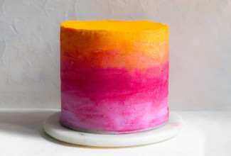 Ombre cake colored with yellow, orange, pink, and purple frosting