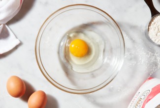 Egg cracked into a clear bowl