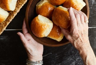 Older hands grabbing bread rolls