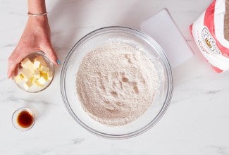 Bowl of flour next to bag of flour and small bowl of cubed butter