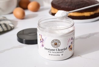 A container of Instant ClearJel in front of a cake