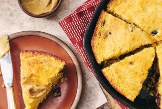 Cranberry Cornbread sliced and in a cast iron pan