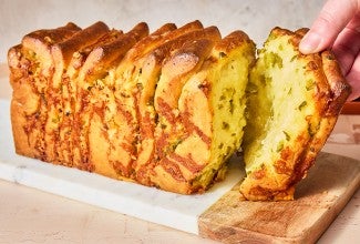 A slice of Jalapeño-Cheddar Pull-Apart Bread being pulled from the loaf