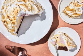 Baked Alaska served on a plate with the full cake on a platter