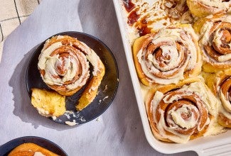 A Sweet Potato Cinnamon Roll on a plate; a bunch in a casserole dish
