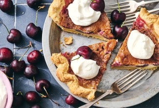 3 slices of Cherry-Vanilla Cream Pie in a pie dish topped with whipped cream