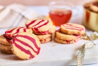 A counter-level view of striped peppermint shortbread cookies showing the scale and shape of the cookie.