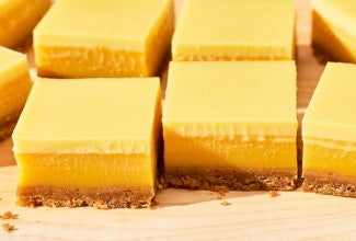 Passionfruit Bars - angled side view - layers of yellow passionfruit curd, crust, and cream.