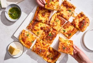 A sliced up Flaky Puff Crust Pizza with pieces being taken out