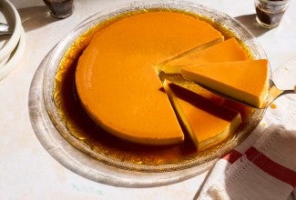 A round flan with three slices and one slice on a pie knife.