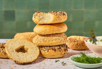 Various bagels stacked on a counter.