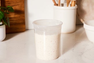 Sourdough starter in quart container on the counter