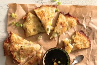 Scallion pancakes cut into wedges with a side of dipping sauce