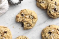 Gluten-Free Almond Flour Chocolate Chip Cookies dusted with sea salt on a marble board